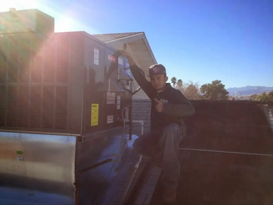 HVAC technician performing Air Duct Cleaning on a rooftop unit in Larkfield-Wikiup